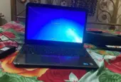 Dell Inspiron N5010 laptop with a silver chassis and a large keyboard.