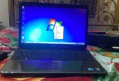 Dell Inspiron N5010 laptop with a silver chassis and a large keyboard.